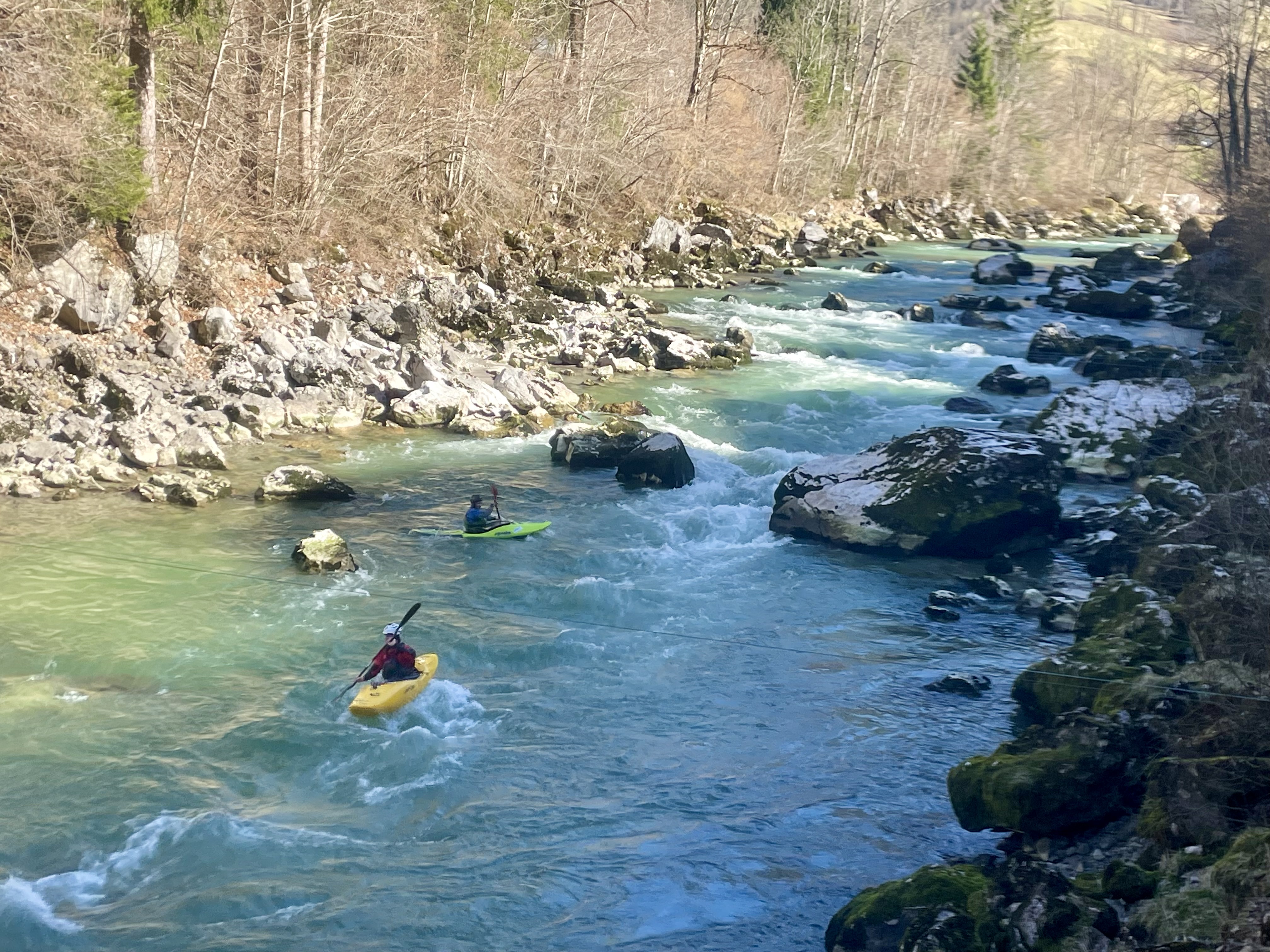 Image of the same two kayakers running the Slalomstrecke