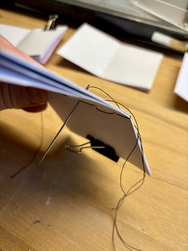 a notebook in the process of sewing
