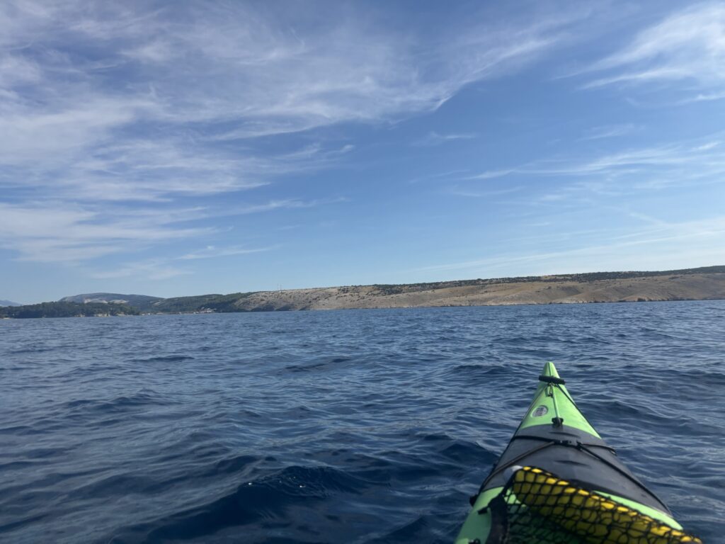 View of the sea, shot over the bow of a green sea kayak